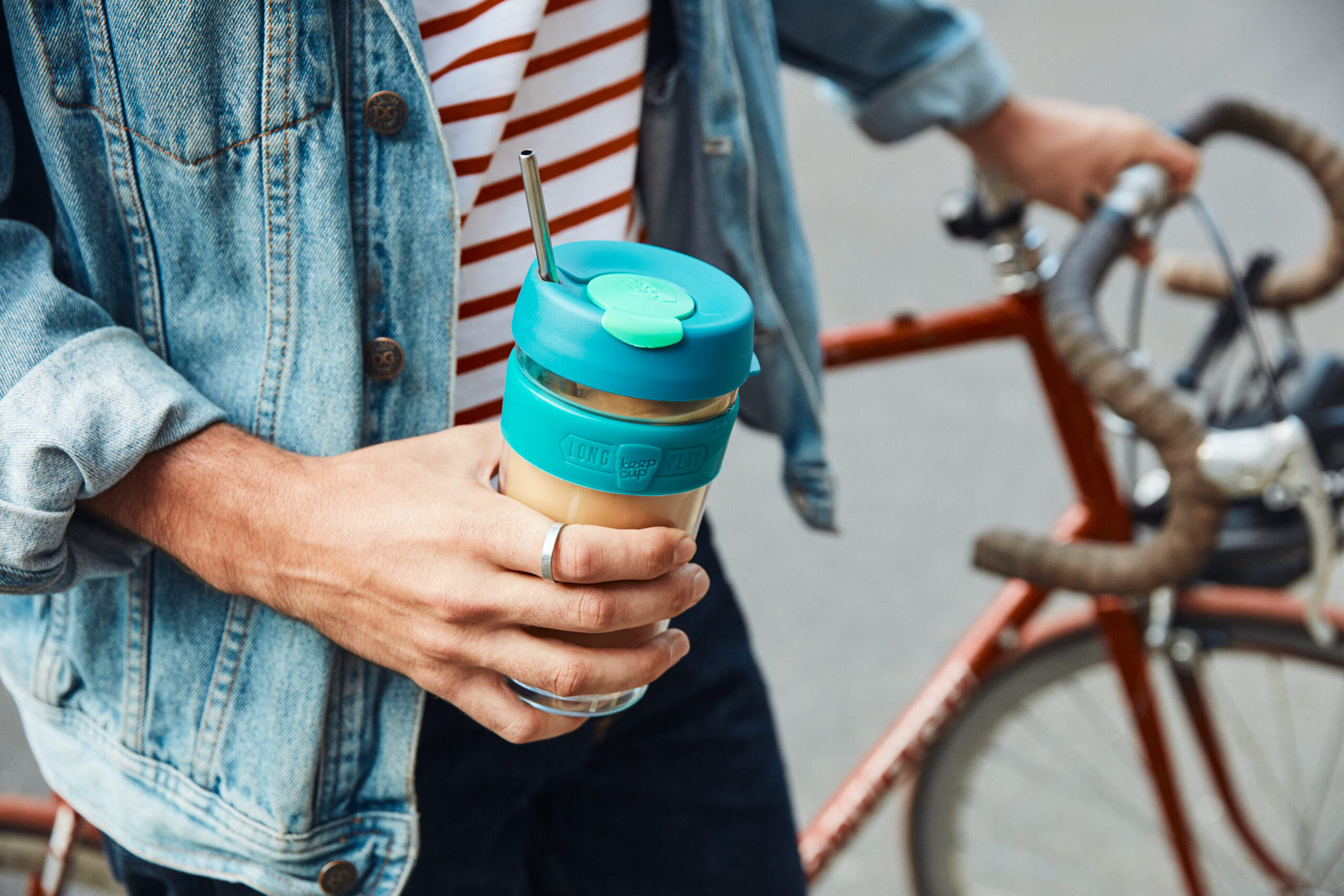 Reusable packaging is gaining a foothold in the fight against waste [Image: Person holding a reusable cup with a metal straw]