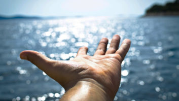 Commitments signaled with photo of a hand outstreched over open water
