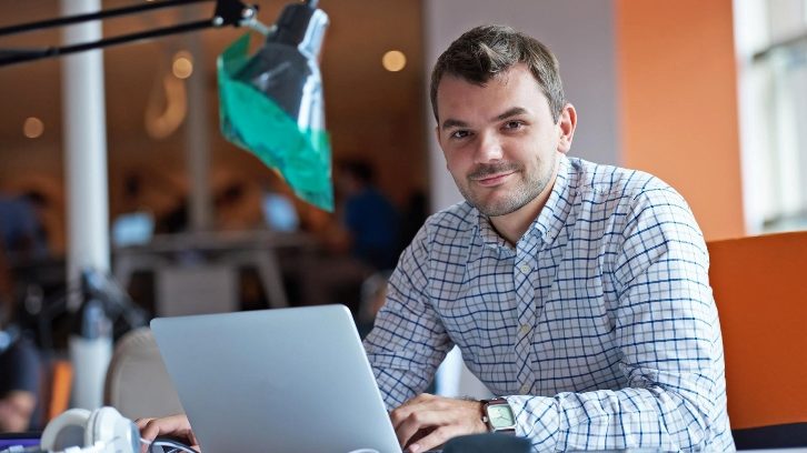 Photo of a man sitting by his laptop to illustrate retaining great employees