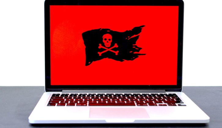 Laptop with black skull and crossbones on red background for education cybersecurity article