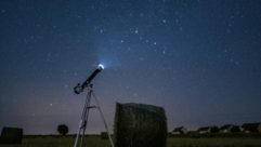 Landscape with telescope pointed toward night sky for space education article