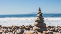 rock cairn among rocks on shore of beach for article on classroom wellness practices