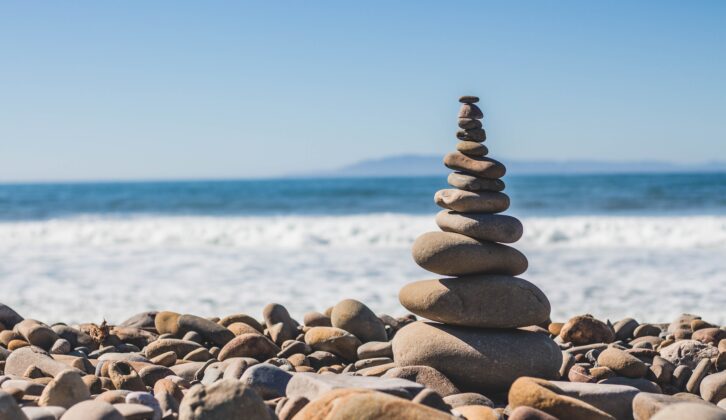 rock cairn among rocks on shore of beach for article on classroom wellness practices
