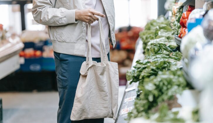 customer uses a reusable bag to shop for vegetables