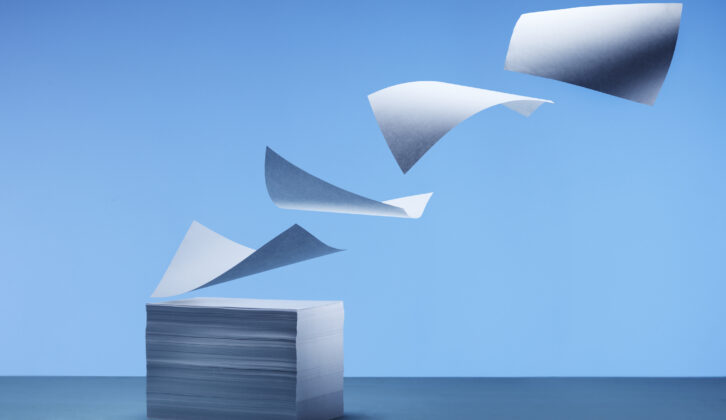 image of papers flying off a stack of papers