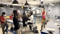 Several students wearing virtual reality goggles as they walk through their classroom for article on sustainability lessons