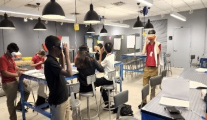 Several students wearing virtual reality goggles as they walk through their classroom for article on sustainability lessons