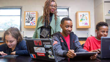 A teacher helps students during a coding lesson at Sutton Middle School. for article on evaluating edtech